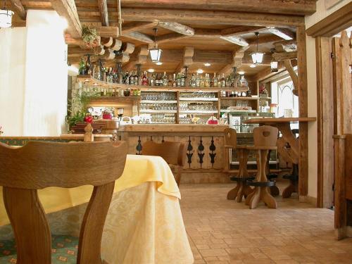 a restaurant with a bar with a table and chairs at Hotel Garni Soreie in Pozza di Fassa