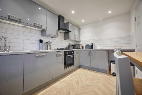 a kitchen with stainless steel appliances and a wooden floor at Host & Stay - Potters Bank in Durham