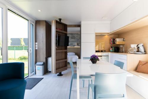 eine Küche und ein Wohnzimmer mit einem Tisch und Stühlen in der Unterkunft Holidaypark Klein Strand in Jabbeke