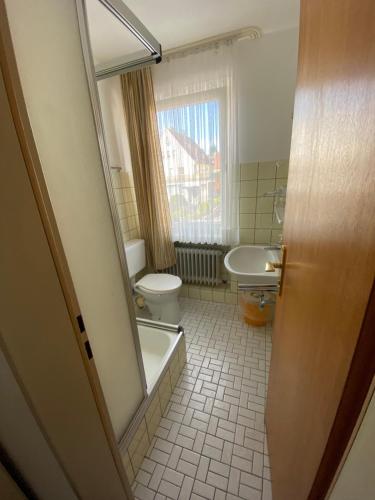 een badkamer met een toilet, een bad en een wastafel bij Hotel Seehaus in Horn-Bad Meinberg