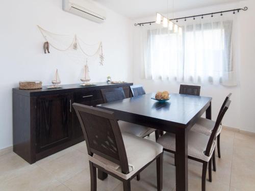 a dining room with a black table and chairs at Apartment Escorxador by Interhome in L'Escala