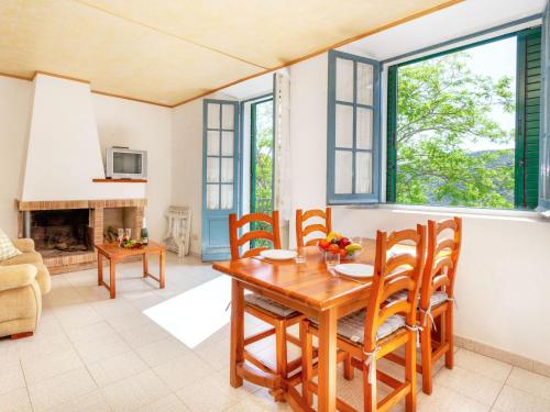 kuchnia i salon z drewnianym stołem i krzesłami w obiekcie Apartment La Rectoria II by Interhome w mieście La Vall de Santa Creu