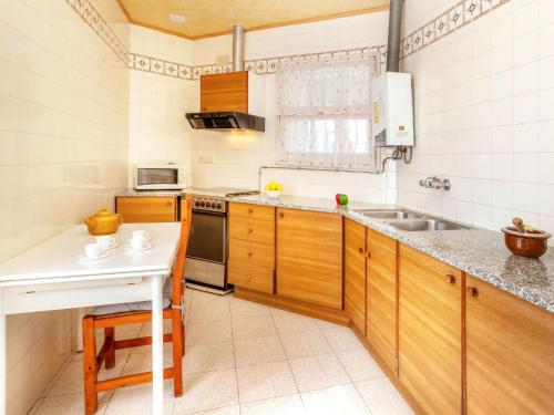 una pequeña cocina con armarios de madera y fregadero en Apartment La Rectoria II by Interhome, en La Vall de Santa Creu