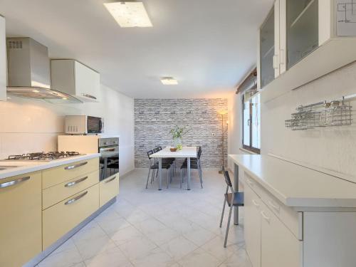 a kitchen with white cabinets and a table in it at Holiday Home Tijan - ROJ411 by Interhome in Žminj