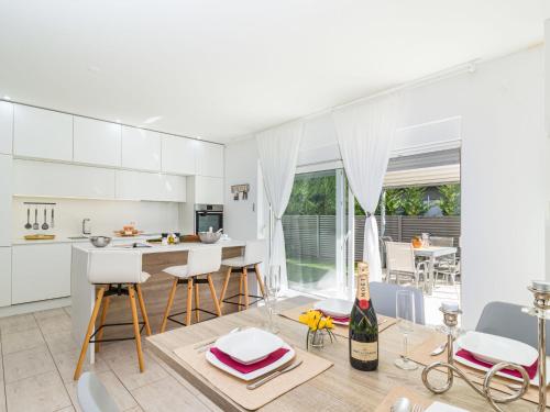 kuchnia z białymi szafkami, stołem i krzesłami w obiekcie Holiday Home Villa Virtus by Interhome w mieście Brtonigla