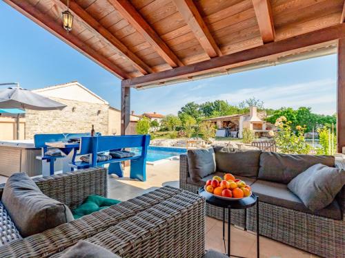 a patio with a couch and a table with fruit on it at Apartment Botra Maria - ROJ458 by Interhome in Sveti Petar u Šumi