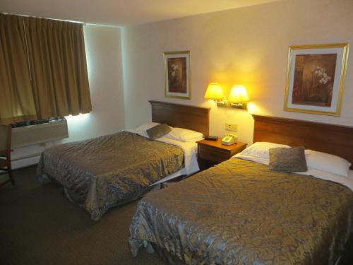 Un pat sau paturi într-o cameră la Ripon Welcome Inn and Suites