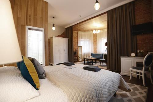 a bedroom with a large white bed in a room at Bahnhofs hotel in Alūksne