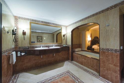 a bathroom with two sinks and a large mirror at Riu Palace Cabo San Lucas - All Inclusive in Cabo San Lucas
