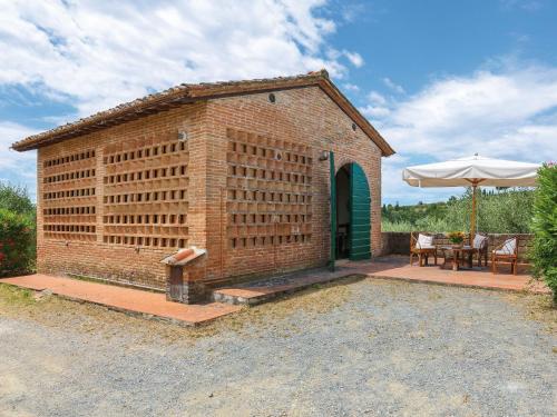 een bakstenen gebouw met een tafel en een paraplu bij Holiday Home Fienile - PAA132 by Interhome in Palaia