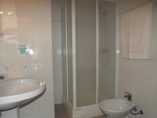 a white bathroom with a sink and a shower at APCOSTAS - Habitat Playa Romana in Alcossebre