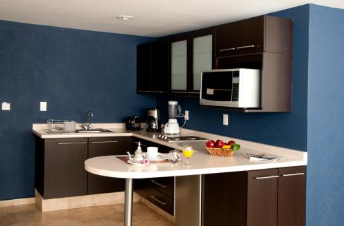 a kitchen with black cabinets and a table with fruit on it at Suites Berna 12 in Mexico City