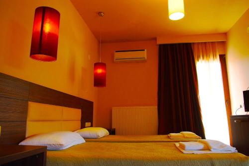 Plotini Hotel في Dhidhimótikhon: غرفة نوم بسريرين عليها مناشف