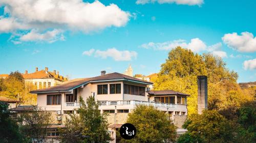 a large building with trees and a blue sky at R34 Boutique Guest House in Veliko Tŭrnovo