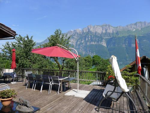 a deck with a table and chairs and an umbrella at Apartment Bünten by Interhome in Oberterzen