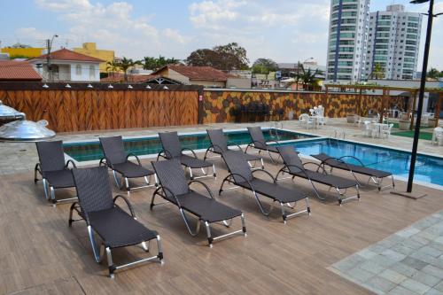 a group of chairs sitting next to a swimming pool at Aquarius Residence in Caldas Novas
