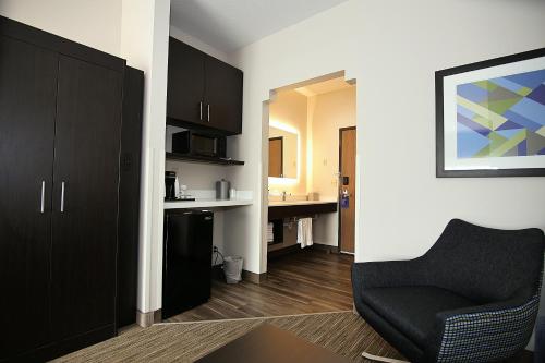 a living room with a chair and a desk at Holiday Inn Express Hotel & Suites Ashland by IHG in Ashland