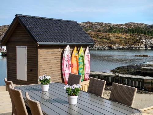 una mesa de madera con sillas y tablas de surf en una casa en Holiday Home Pale - FJH104 by Interhome en Bømlo