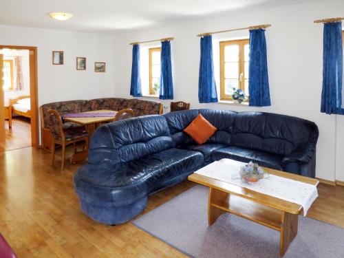 a living room with a black leather couch and a table at Holiday Home Kreuzbuche by Interhome in Viechtach