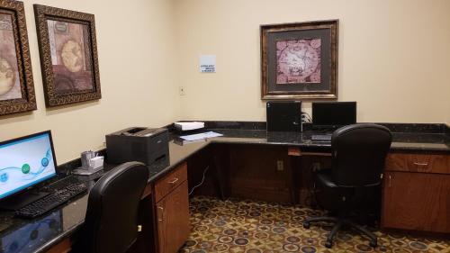 an office with a desk with a computer and two chairs at Holiday Inn Express & Suites Galveston West-Seawall in Galveston