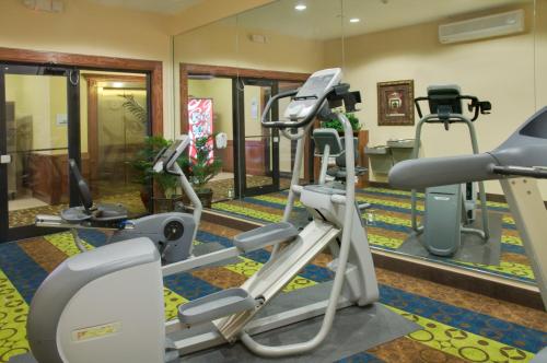 a gym with two tread machines and a mirror at Holiday Inn Express & Suites Galveston West-Seawall in Galveston