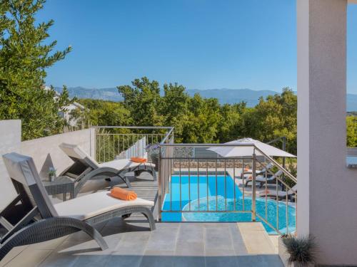 een balkon met stoelen en een zwembad bij Holiday Home Lavendel - MLK159 by Interhome in Dobrinj