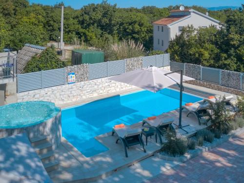 an overhead view of a swimming pool with an umbrella and chairs at Holiday Home Lavendel by Interhome in Dobrinj