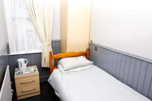 a small bedroom with two beds and a window at Mallowview guest house in Cleethorpes