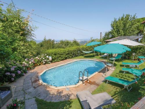 a swimming pool with two umbrellas and chairs at Holiday Home Villetta nel Verde by Interhome in Montaione