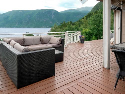 a couch on a deck with a view of the water at Holiday Home Lyktvorholmen - FJS618 by Interhome in Hopperstad
