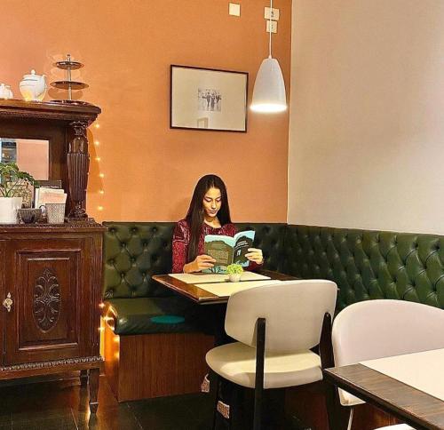 a woman sitting at a table reading a book at Hotel Chemin in Buenos Aires