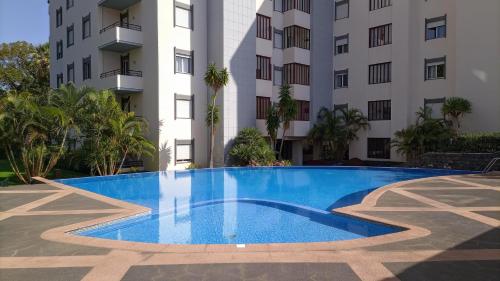 a swimming pool in front of a building at Garden's Apartment in Funchal