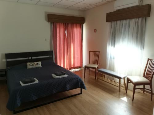 1 dormitorio con 1 cama, 2 sillas y ventana en Kakopetria Heights, en Kakopetria