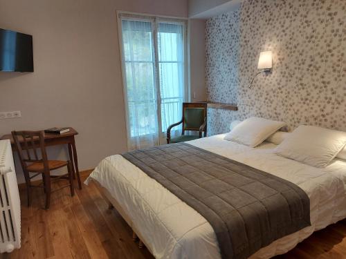 une chambre avec un lit, un bureau et une chaise dans l'établissement Hôtel La Montagne Fleurie, à Barèges