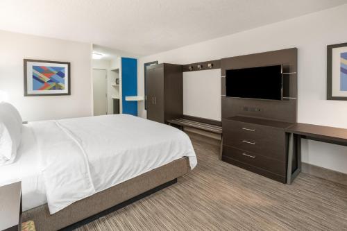 a hotel room with a bed and a flat screen tv at Holiday Inn Express Hotel & Suites Albuquerque - North Balloon Fiesta Park by IHG in Albuquerque