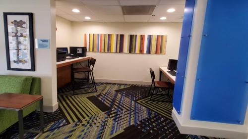 an office with a desk and a computer on a wall at Holiday Inn Express & Suites Arlington North – Stadium Area by IHG in Arlington