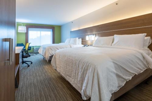 a hotel room with two beds and a desk at Holiday Inn Express & Suites Arlington North – Stadium Area by IHG in Arlington