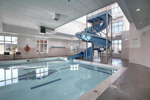 a swimming pool with a slide in a building at Holiday Inn Express Airport Calgary, an IHG Hotel in Calgary