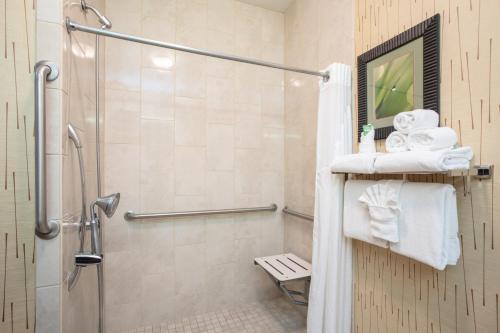 a bathroom with a walk in shower and towels at Holiday Inn Express Hotel & Suites Gillette by IHG in Gillette