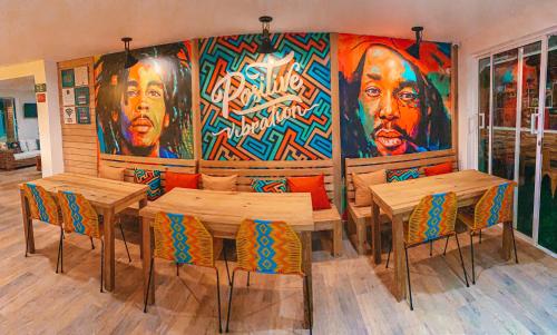 a restaurant with wooden tables and chairs and a large mural at In Di House of Reggae Boutique in San Andrés