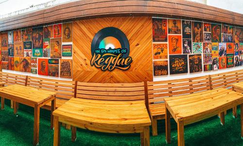 a building with benches and posters on the wall at In Di House of Reggae Boutique in San Andrés