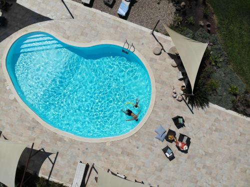 an overhead view of a swimming pool with people in it at Is Cheas wine farm boutique hotel in San Vero Milis