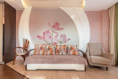 a bedroom with a bed with pink flowers on the wall at Apartment On Nesebrskaya 14 in Sochi