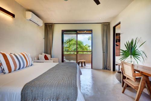 a bedroom with a bed and a desk and a window at Privada Soliman Bay villa pets welcome! in Tulum