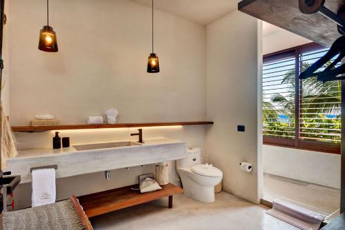 a bathroom with a sink and a toilet at Privada Soliman Bay villa pets welcome! in Tulum