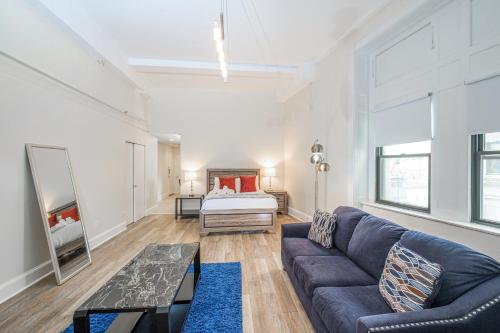 a living room with a couch and a bed at Evonify Stays - Theatre District Apartments in Boston