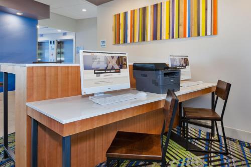 a desk with a computer and a printer on it at Holiday Inn Express & Suites - Grand Rapids Airport - South by IHG in Grand Rapids