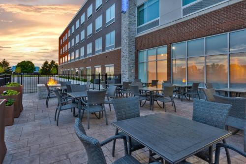 a patio with tables and chairs in front of a building at Holiday Inn Express & Suites - Grand Rapids Airport - South by IHG in Grand Rapids