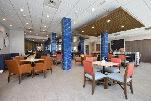 a restaurant with tables and chairs and blue columns at Holiday Inn Express & Suites Spring - Woodlands Area by IHG in Spring