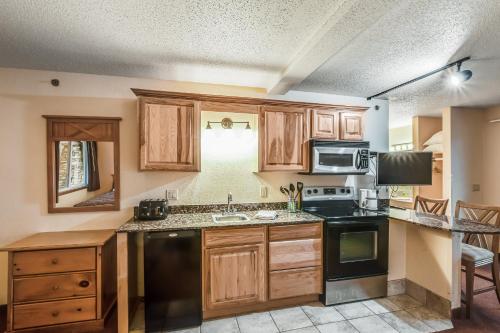 una cocina con armarios de madera y electrodomésticos negros en Chula Vista Villas, en Wisconsin Dells